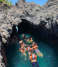 Grupo de gente nadando en cueva de agua