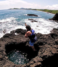 Hombre saltando hacia cueva de Playa Ermitas