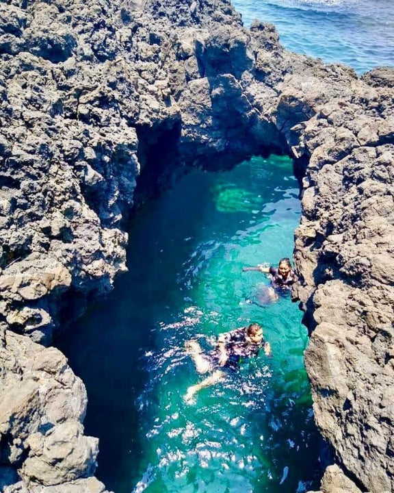 Gente nadando al interior de una cueva marina