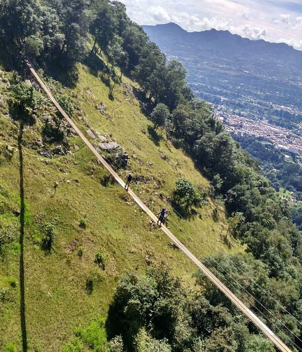 Personas cruzando puente colgante en Tlatlauquitepec